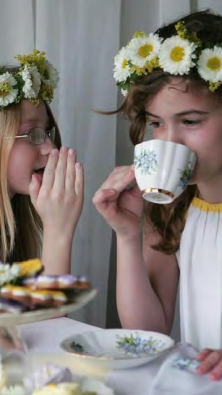two young girls sipping tea