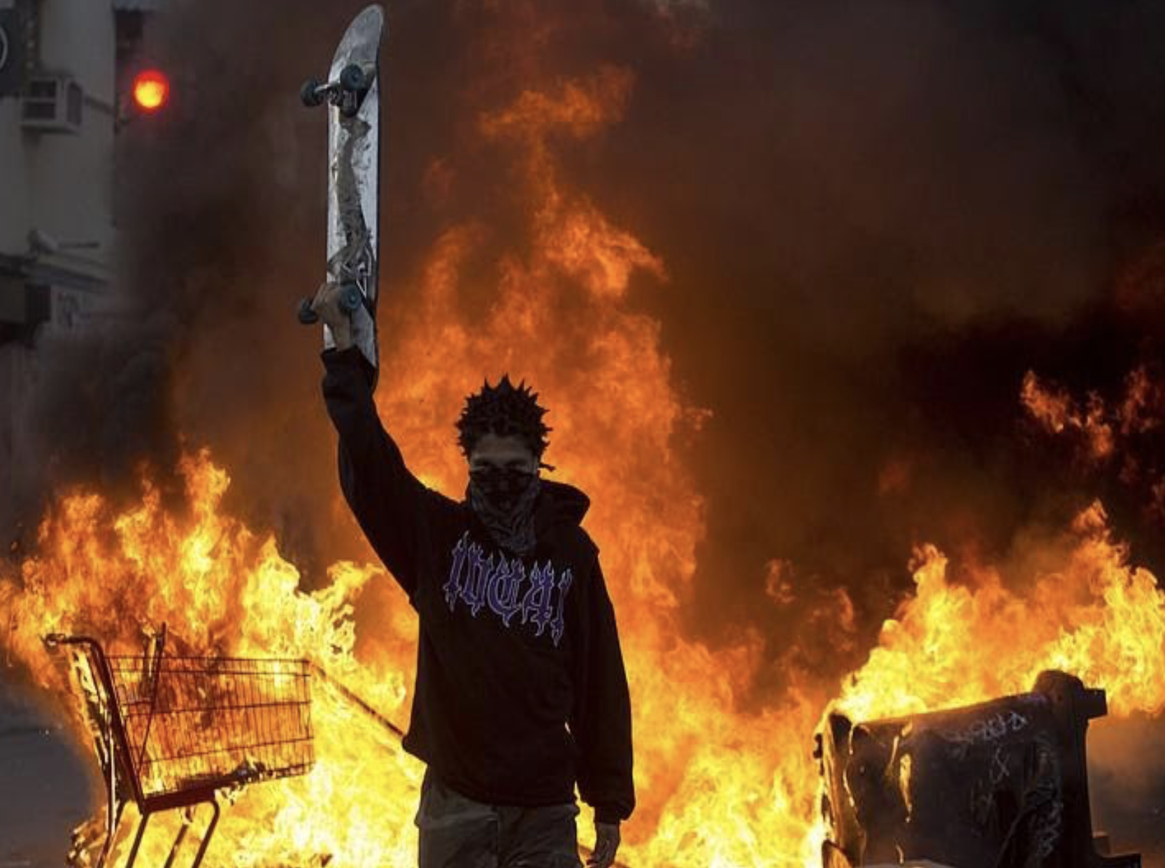 man holding skateboard in fire