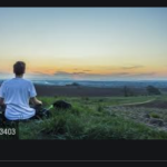 person sitting watching sunset