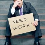 man with "need work" sign