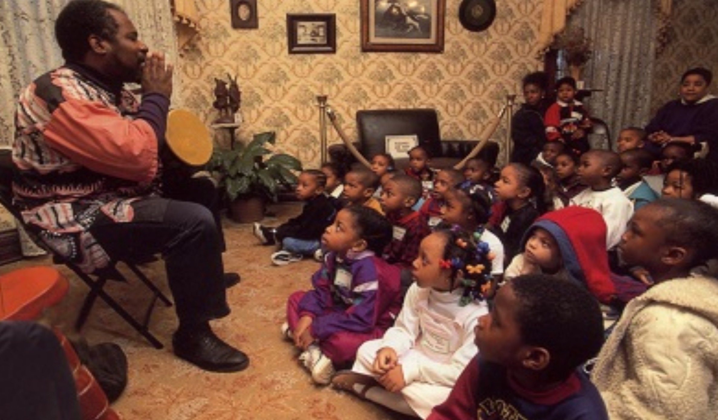 man talking to a room full of children